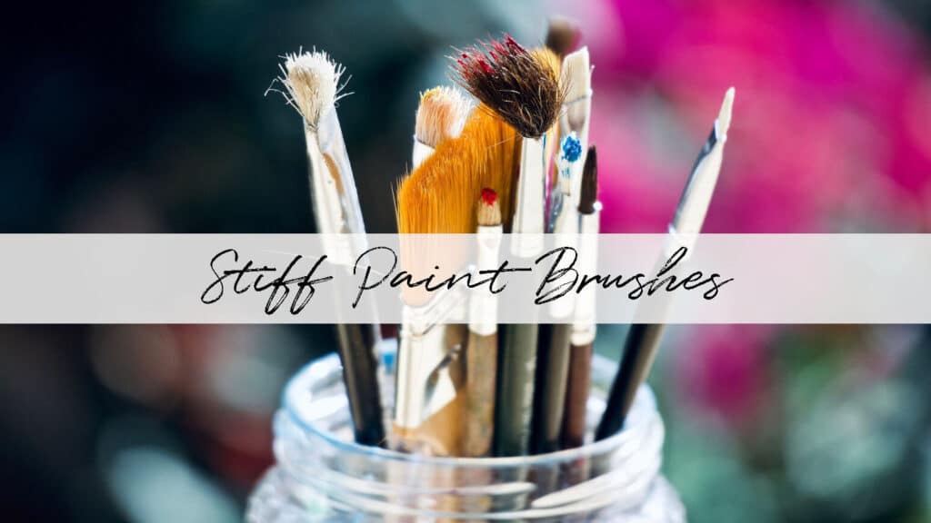 A jar full of assorted paint brushes that have paint on them and the title "Stiff Paint Brushes"