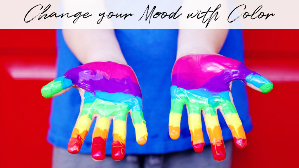 Open hands covered in rainbow colored paint, explaining how you can change your mood with color.
