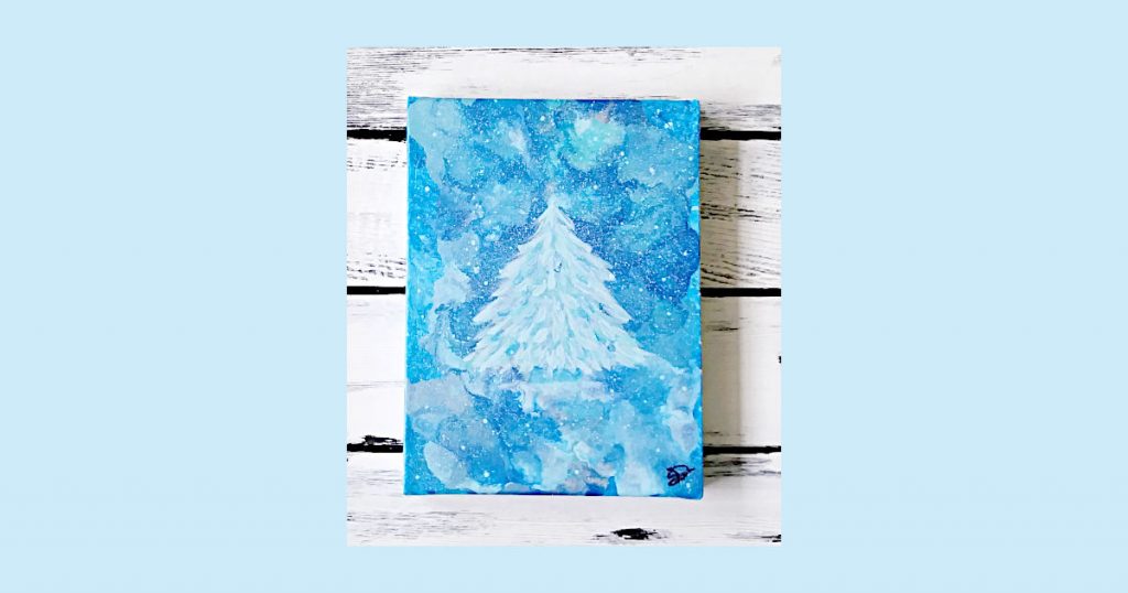 An acrylic painting of an icy blue, snow covered Christmas tree on a marble background using assorted blue paint, including blue metallic paint