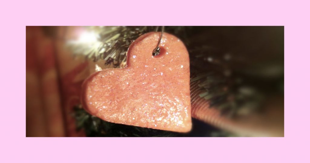 Glittery pink heart ornament hanging on a Valentine's Day Tree