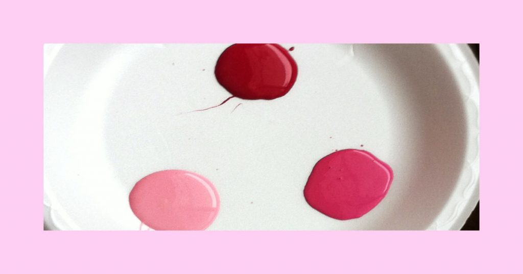 Different shades of pink paint on a white palette