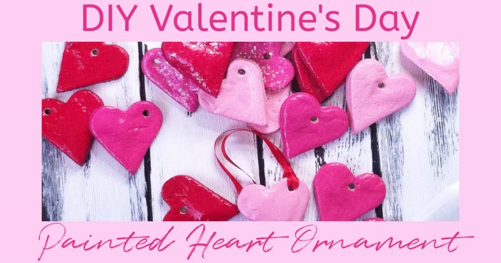 Pretty pink and red heart ornaments on a white washed wooden backgrounds. Text overlay reads: DIY Valentine's Day Painted Heart Ornament"