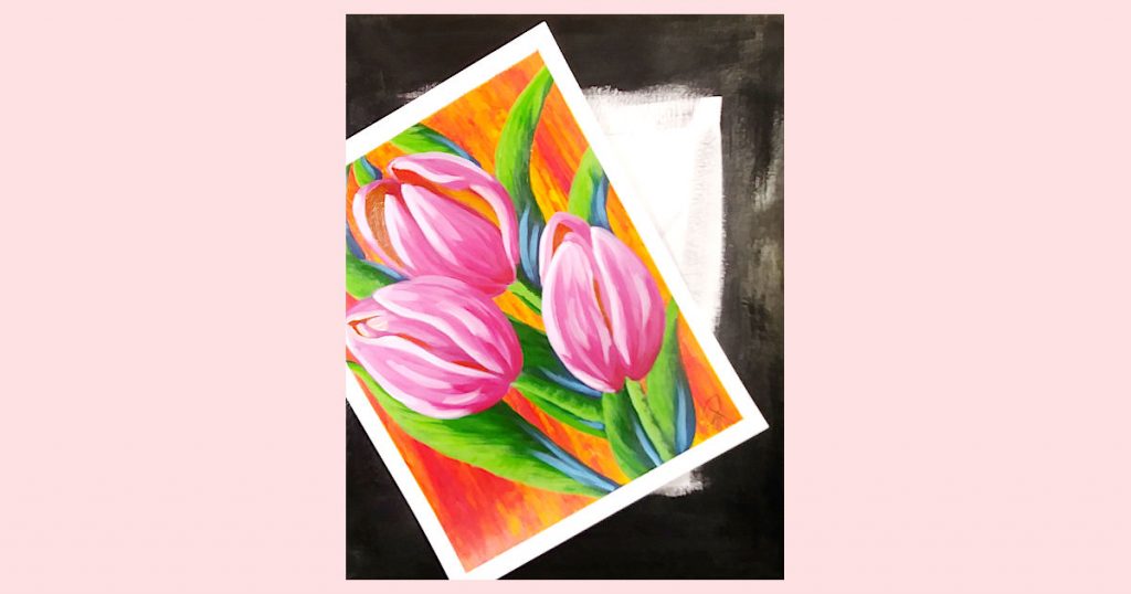 A finished pink tulip paper painting laying on top of a canvas with black painted edges