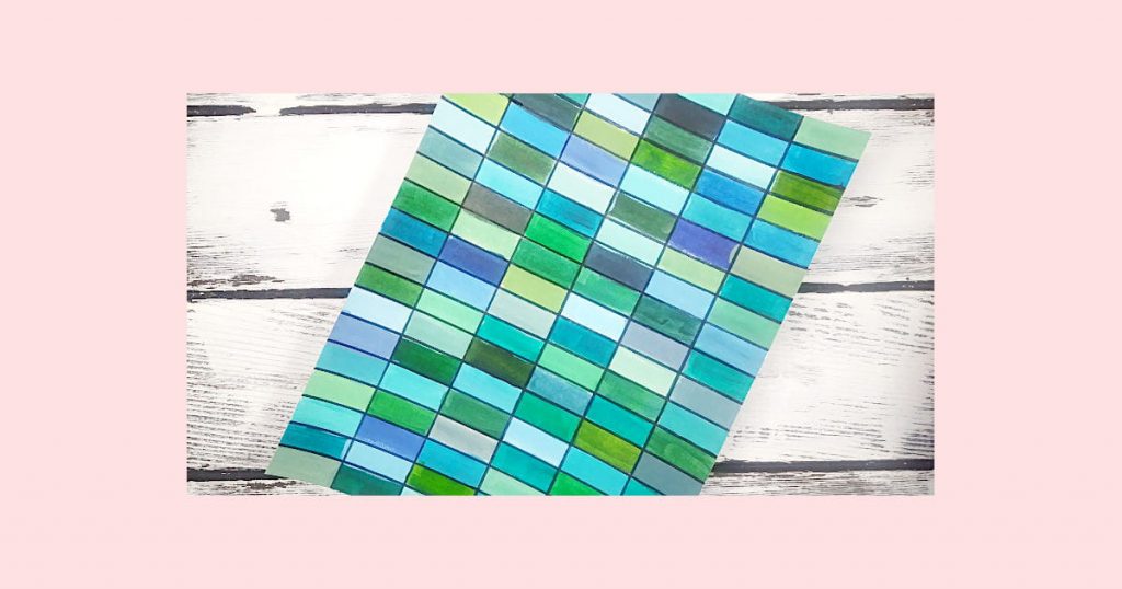 A Piece of paper covered in all of the different blue, green, and turquoise paint swatches made in the experiment.