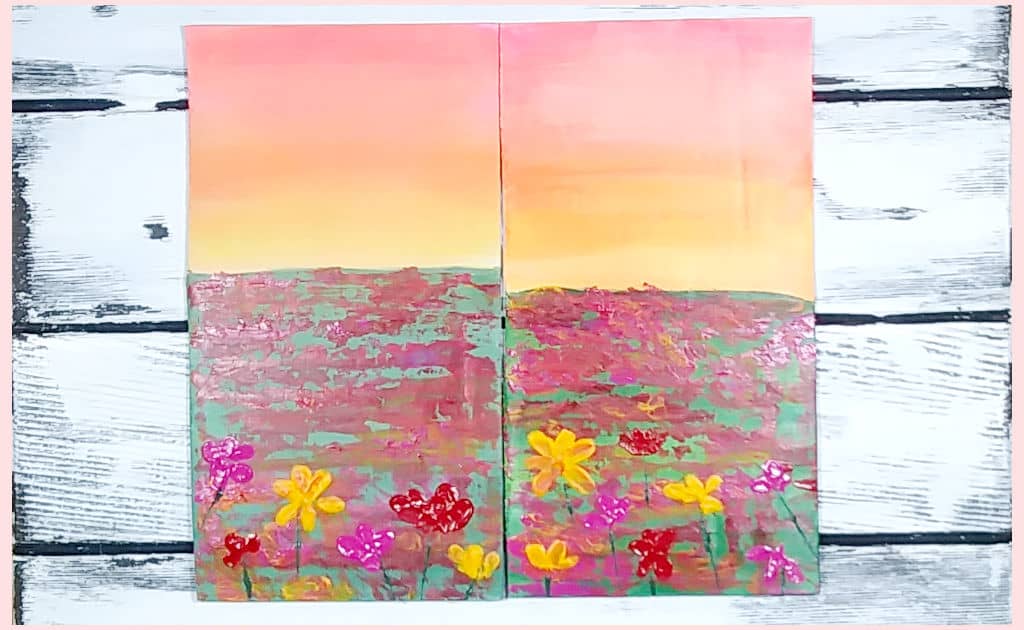 Two pieces of corrugated cardboard, painted with a sunset flower field scene, as a side-by-side comparison between using gesso or white paint to prime the cardboard.