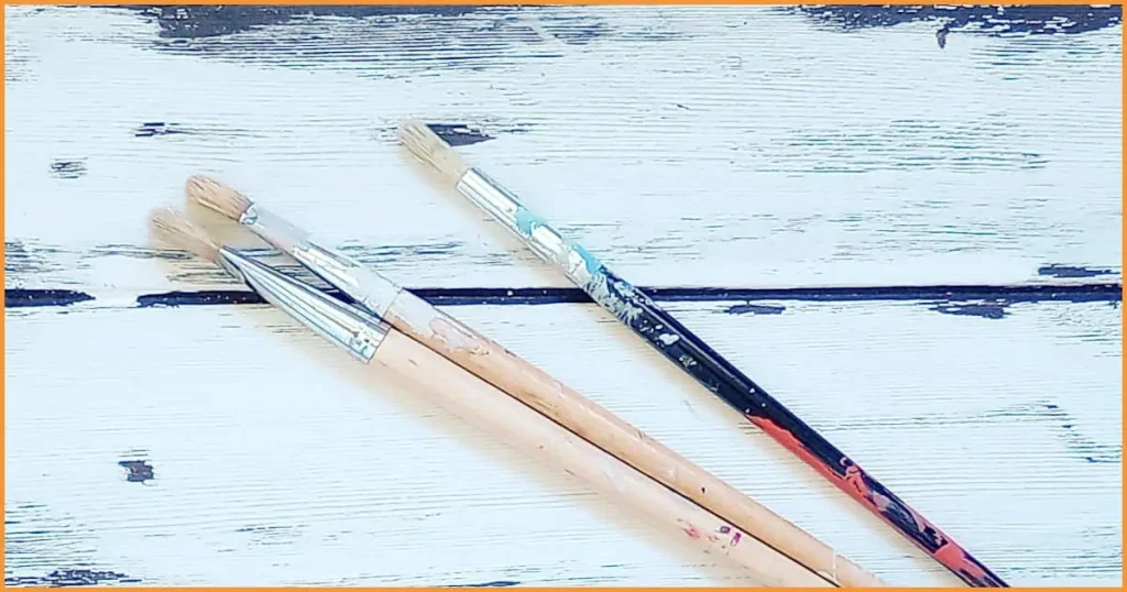 Three paintbrushes with very stiff bristles. These type of brushes work well for scrubbing and scumbling but be careful to squeeze as much water as possible out of them before applying paint.