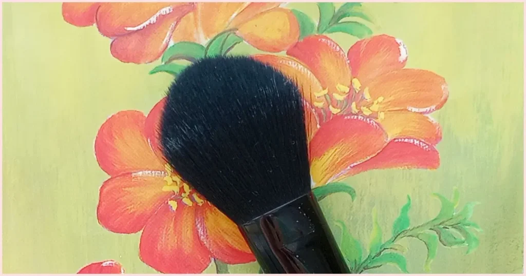 A black mop brush on an orange floral background.