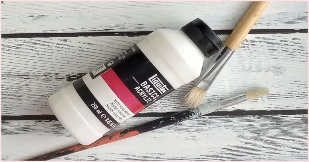 A bottle of Matte medium and two paintbrushes.